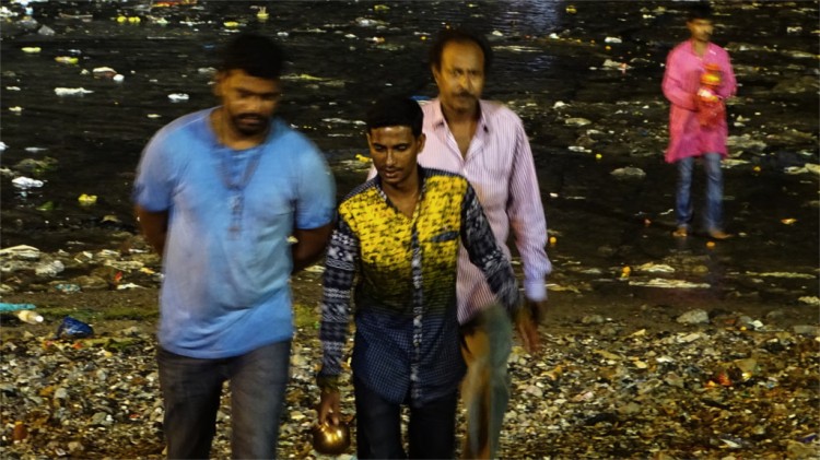 A family returns after immersing their idol in the sea
